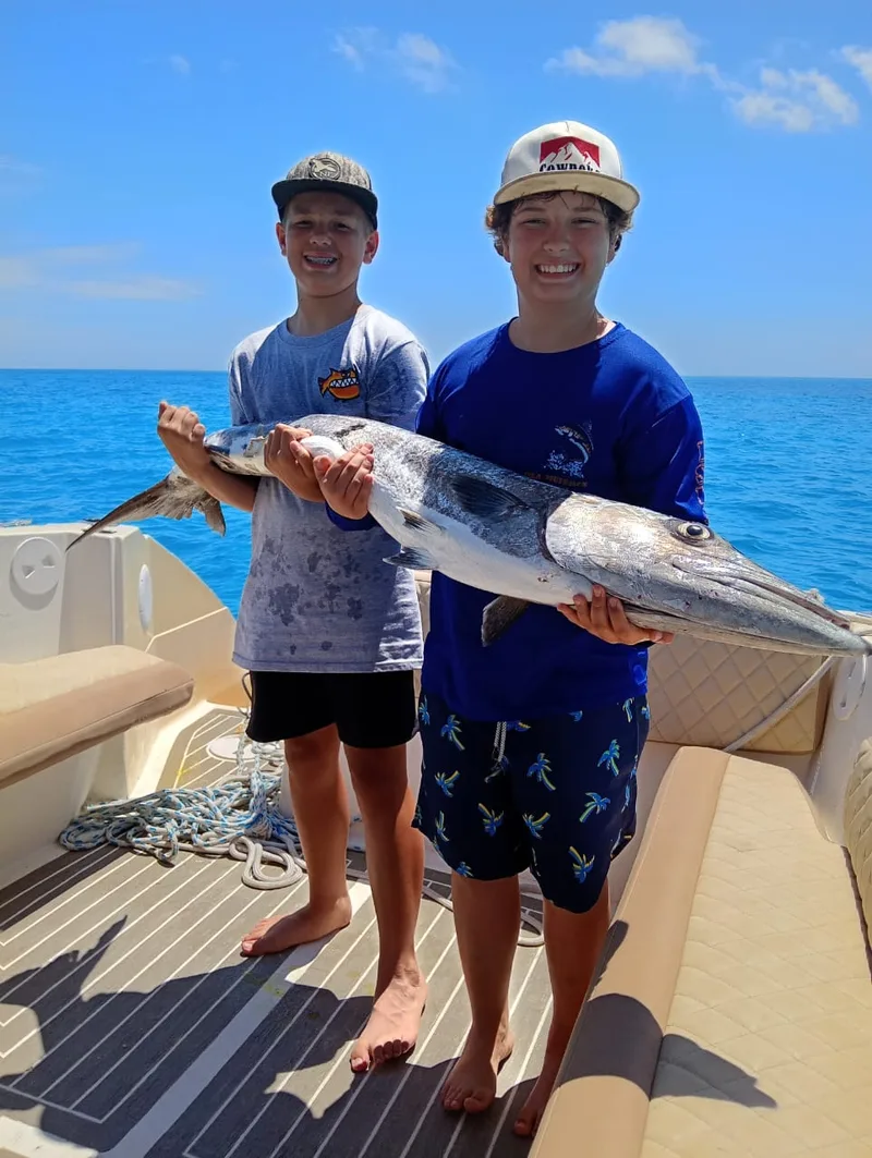 Niños con su captura en un charter de pesca en Isla Mujeres